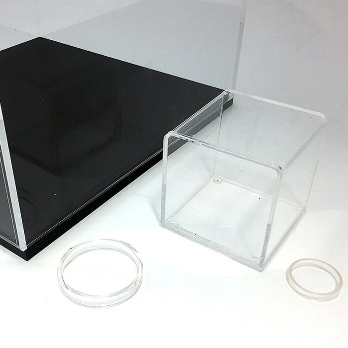 Detailansicht einer kleinen transparenten Acrylbox mit abnehmbarer Bodenplatte und losem Acrylring.