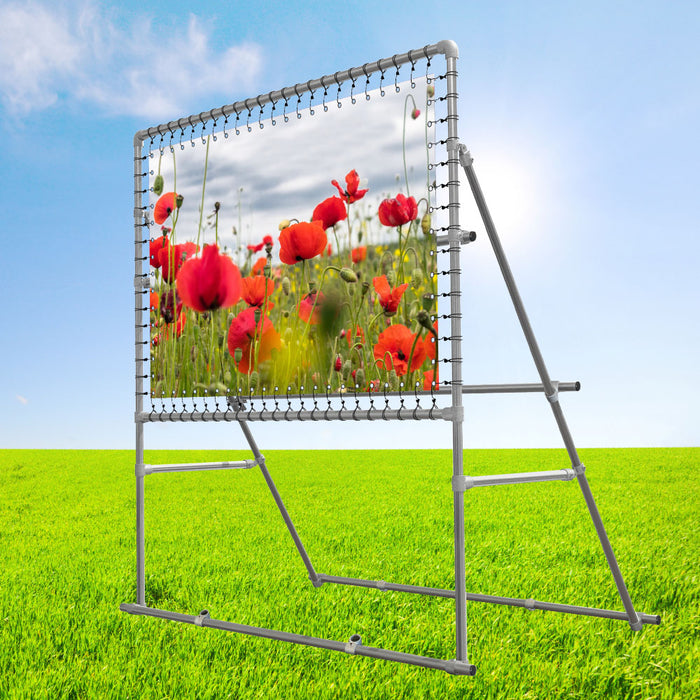 Bannerrahmen auf Hochständer mit PVC-Banner mit Mohnblumen auf einer grünen Wiese unter blauem Himmel