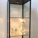 Beleuchtete Glasvitrine Solo Tower mit ausgestellten Gläsern und Dekorationsartikeln