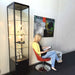 Beleuchtete Glasvitrine Solo Tower im Showroom mit ausgestellten Produkten