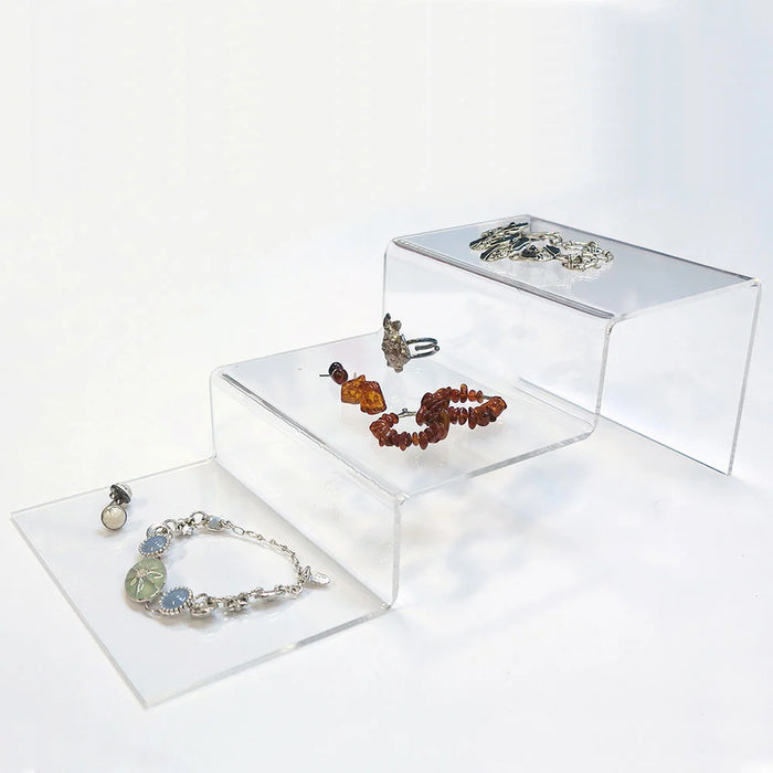 Transparentes Acryl-Treppenpodest mit drei Stufen zur Präsentation von Schmuck und Accessoires.