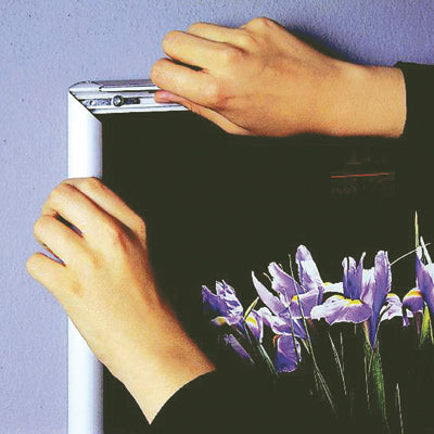 Klapprahmen Silber mit Blumenposter, Hände klappen die obere Profilleiste zu